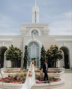 a bride and groom standing in front of a church