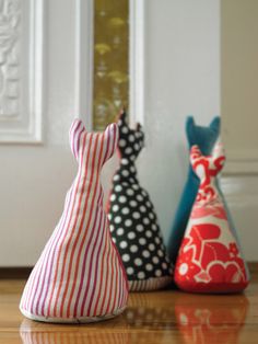 three colorful vases sitting on top of a wooden floor