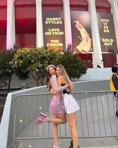 two young women posing for a photo in front of the hollywood studios building with their arms around each other