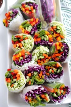 there are many different types of veggies in rolls on the plate and one is cut into small pieces