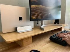 a computer monitor sitting on top of a wooden desk next to a keyboard and mouse