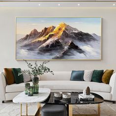 a living room filled with furniture and a large painting on the wall over a white couch