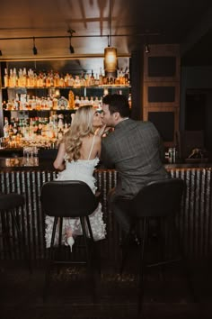 a man and woman sitting at a bar kissing