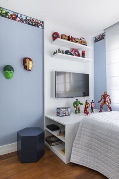 a bedroom with blue walls, white furniture and toys on the shelves above the bed