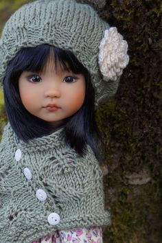 a doll wearing a knitted hat and scarf