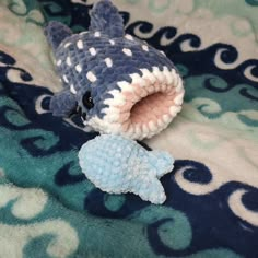 a small stuffed shark laying on top of a blanket