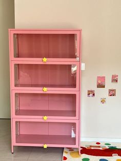 a pink bookcase sitting on top of a rug