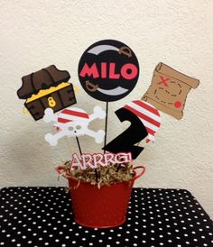 a red bucket filled with lots of assorted items on top of a black and white table