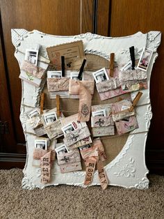 an old photo frame with clothes pins and pictures pinned to it on the wall next to a carpeted floor