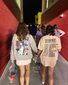 two girls walking down a hallway holding hands