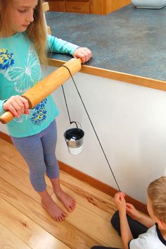 two children are playing with a toy baseball bat and bucket on the floor in front of them