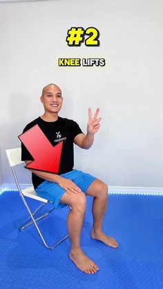 a man sitting on a chair with his hand up in the air while holding a red and black object