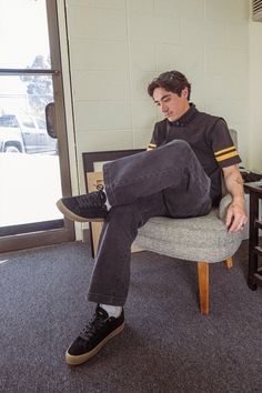 a man sitting in a chair with his feet up on the back of another chair