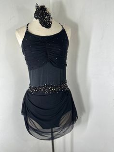 a mannequin wearing a black dress with beading on it