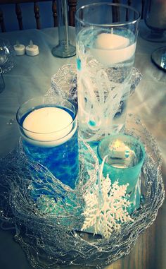 there are two glasses on the table and one is filled with blue liquid, while another glass has snowflakes in it