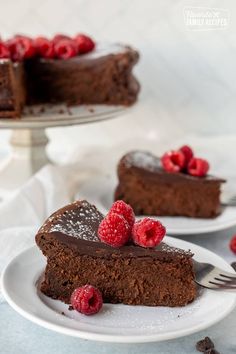 a slice of chocolate cake with raspberries on the top and one piece missing