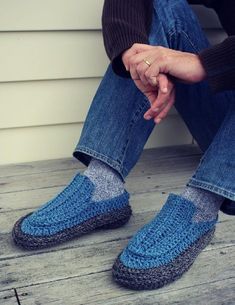 a person sitting on the ground wearing blue slippers