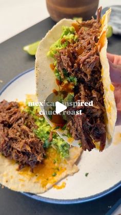 someone is holding up a taco with meat and guacamole