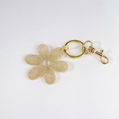 Elevate your accessories with our Sparkling Gold Daisy Bag Charm. This enchanting charm features a beautifully crafted daisy design, adorned with glitter to add a dazzling sparkle to your bags, keys, or any item you choose. The golden hue and shimmering finish make it a standout piece, perfect for adding a touch of glamour and elegance to your everyday essentials. Imagine the charm and personality it brings, making your items uniquely yours. The sturdy clasp ensures easy attachment and secure ho Trendy Gold Keychain For Everyday Use, Trendy Gold Keychains For Gift, Daisy Bags, Daisy Design, Back To School Sales, Flower Bag, Market Tote, Gold Flower, Coin Pouch