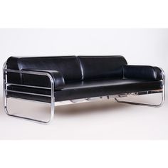 a black leather couch sitting on top of a metal frame