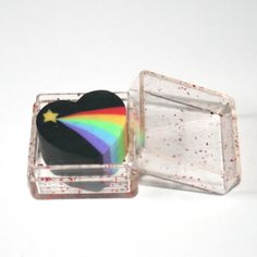 a heart shaped cake in a clear box with sprinkles on the lid