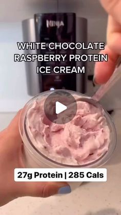 a person is holding a container of raspberry protein ice cream