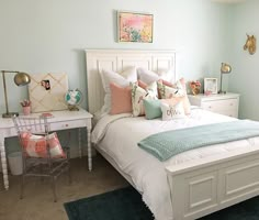 a white bed sitting in a bedroom next to a desk