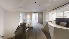 an empty room with wooden floors and white walls, along with glass railings that lead to the second floor