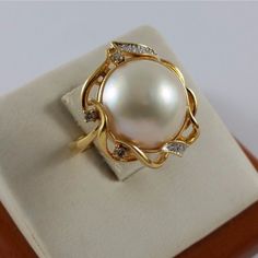 Hello And Thanks For Checking Out Another Great Listing From Golden Route! We Hope You Enjoy The Photos And Information Presented Herein. If You Have Any Questions, Feel Free To Contact Us For A Prompt And Friendly Response Beautiful 18k Karat 750 Yellow Gold Mabe Pearl & Diamond Ring Condition : Pre-Owned Professionally Polished To Look New Total Weight : 8.7 Grams Gold Color : Yellow Gold Pearl Size : 14.20mm Total Of 10 Round Cut Diamonds (Please See Pictures For More Detail On The Sizes; They Are By Millimeter) This Item Is Presented To You By H&R Jewelry & Loan Co. We Are A Jewelry Store/Pawn Shop Serving The San Fernando Valley, Ca Since 1985, In The Same Location And Under The Sa Pearl Diamond Ring, Pearl And Diamond Ring, Mabe Pearl, Fancy Earrings, Rose Gold Band, Pearl Diamond, Pearl Size, Gold Pearl, Pearl Ring