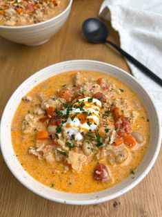 two bowls filled with soup on top of a wooden table