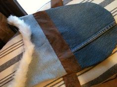 a blue jean bag sitting on top of a bed