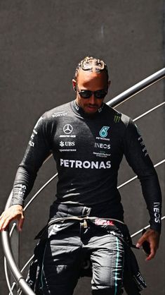 a man in a wet suit and goggles is walking up some stairs with his hand on the railing