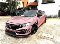 a pink car parked in front of a building