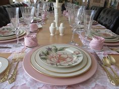 the table is set with pink and white china