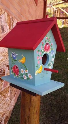 a bird house painted with flowers and birds