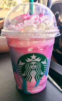 a starbucks drink with pink and blue swirled toppings on the side sitting on a table