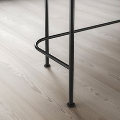 a black stool sitting on top of a hard wood floor