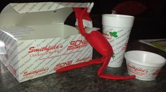 an elf in a box and cups on a table