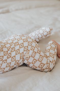 a baby laying on top of a white bed