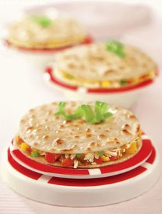 two tortilla sandwiches are on a red and white plate