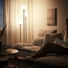 a living room scene with focus on the couch and floor lamp in the corner,