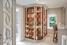 a closet with many shoes and purses on shelves in it's center area