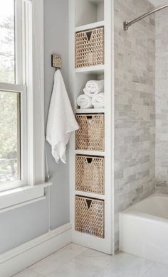 a bathroom with white towels and baskets on the shelf next to the bathtub is shown