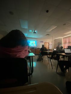 people are sitting at desks in an empty classroom