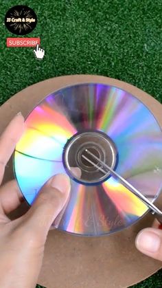 a person holding a cd in their hand on top of a green grass covered field