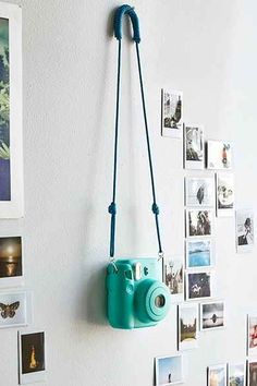 a blue camera hanging on the wall next to pictures