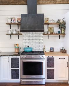 a stove top oven sitting inside of a kitchen next to open shelving above it