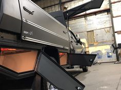 the back end of a truck with its doors open in a warehouse or workshop area