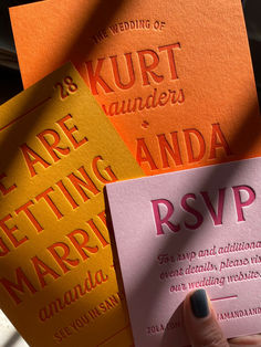 a person holding up some cards with the word rsvp printed on them in different colors