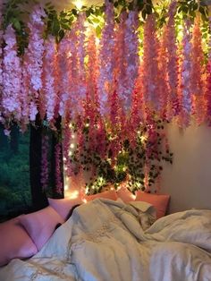 the bed is covered with pink flowers hanging from it's headboard and pillows